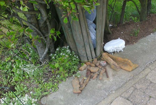 Rusted artillery shells and munitions left near a present day farmer's bin on the former Passchendaele WW1 battlefield.
