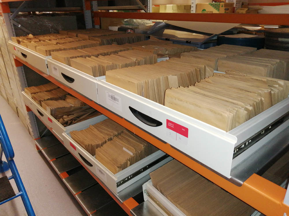 Draws of documents kept in brown envelopes in a storage facility.